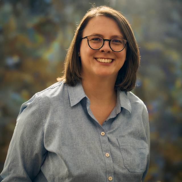 Katie Allred, founder of Chilton Sites, smiling outdoors in a blue button-down shirt
